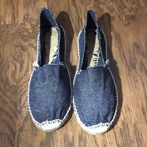 Denim canvas espadrilles with white stitching.